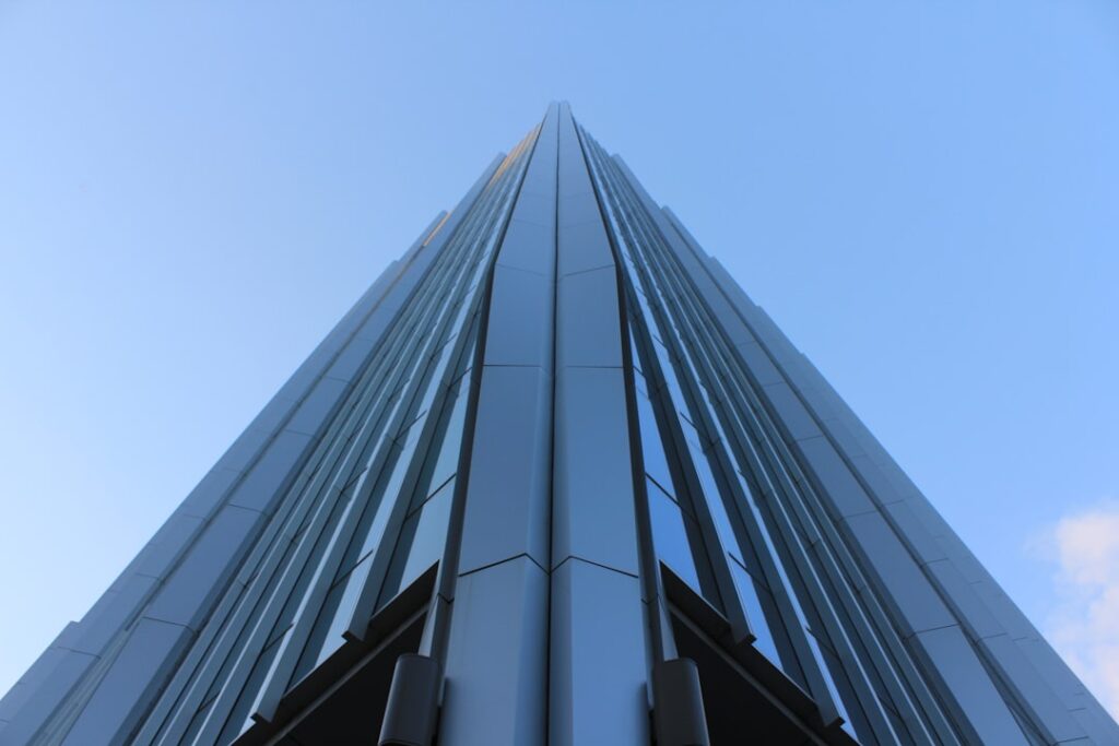 An angular skyscraper rises into the blue sky.